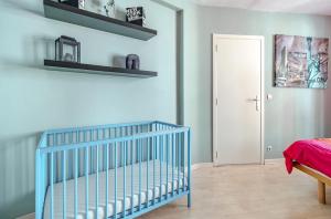 a blue crib in a room with a door at Appartement 20 min du Circuit Spa-Francorchamps, in Verviers