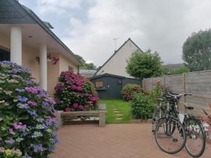 two bikes parked in front of a house with flowers at Tous à l'ouest in Combrit