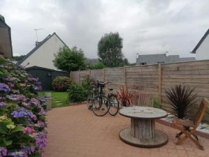 a patio with two bikes and a table and a fence at Tous à l'ouest in Combrit