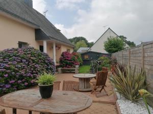 a patio with a table and chairs and flowers at Tous à l'ouest in Combrit