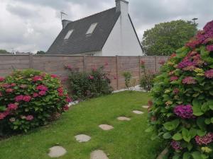 a garden with flowers and a fence and a house at Tous à l'ouest in Combrit