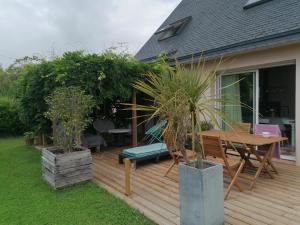 a wooden deck with a table and chairs on it at Tous à l'ouest in Combrit