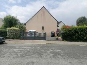 a large white church with a gate and a car parked outside at Tous à l'ouest in Combrit