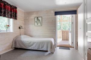 Rural apartment in Sjoared في ماركاريد: غرفة نوم بسرير وباب زجاجي منزلق