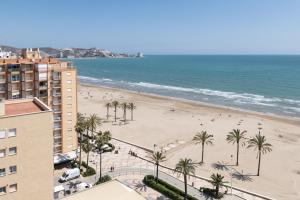a view of a beach with palm trees and a building at Lider, 12-G in Cullera