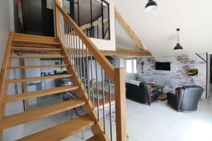 escalera de madera en la sala de estar con sofá en Au tour des sens, en La Jumellière