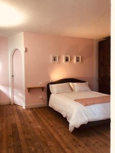 a bedroom with a large bed with white sheets at La casa nei campi in Badia Pavese
