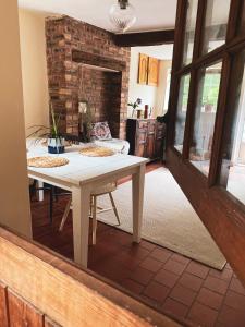 a living room with a table and a brick wall at Boutique country hideaway ‘Jacks Cottage’ in Diddlebury