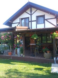 ein Haus mit einer Veranda mit einem Tisch und Stühlen in der Unterkunft Ribarska Vila in Donje Lohovo