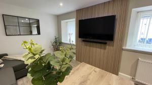 a living room with a flat screen tv on a wall at The Forge, Elegant Luxury Apartment with Bike store - Sleeps 4 in Wick