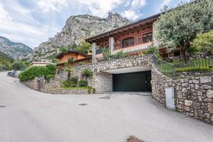 uma casa de pedra com garagem em frente a uma montanha em Casa Francesca Relax em Limone sul Garda
