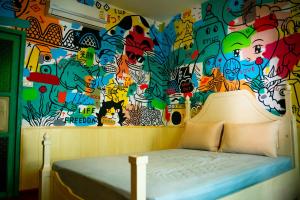 a bedroom with a wall covered in graffiti at Hostel and Music Bar Bros in Pai