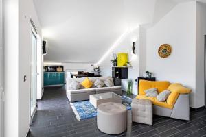 sala de estar con muebles blancos y amarillos en Colonno Penthouse, en Colonno