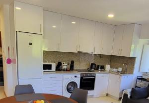 a kitchen with white cabinets and a washer at Casa Barca Velha in Ponte da Barca