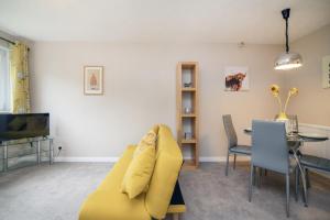 Una sala de estar con un sofá amarillo y una mesa. en The Kelvin - Peaceful West End River View Property, en Glasgow