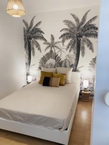 a bedroom with a bed with palm trees on the wall at Beure maison chaleureuse et cosy in Beure