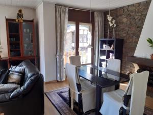 a dining room with a black table and white chairs at Areny Arinsal hasta 6 personas in Mas de Ribafeta +9 photos