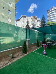 un balcón con césped verde y una pista de tenis en dagkent plus suit, en Tokat