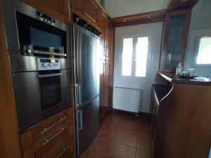 a kitchen with a stainless steel refrigerator and a microwave at Borgo Majoca - Μονοκατοικία σε κυκλαδίτικο νησί in Mési