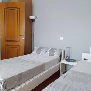 a bedroom with two beds and a wooden door at Borgo Majoca - Μονοκατοικία σε κυκλαδίτικο νησί in Mési