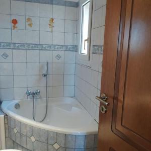 a bathroom with a bath tub and a window at Borgo Majoca - Μονοκατοικία σε κυκλαδίτικο νησί in Mési