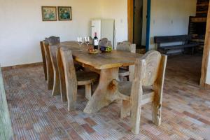 クルベロにあるFazenda Com Piscina e Churrasqueira Curveloの木製テーブル(椅子付)、ワイングラス