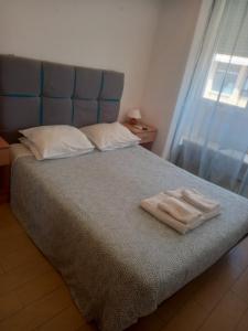 a bedroom with a bed with two towels on it at quarto suite em Belém in Lisbon