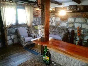 Sala de estar con sofá y botella de cerveza en Ribarska Vila, en Donje Lohovo