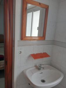 uma casa de banho com um lavatório e um espelho em La redonda em San Roque