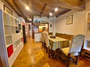 a dining room with a table and chairs and a kitchen at Pleta de Ordino 55 Casa Rústica hasta 6 personas in Ordino