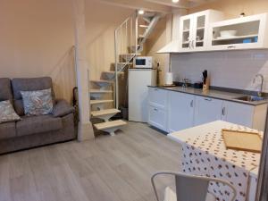 kuchnia i salon z kanapą i stołem w obiekcie Apartamentos Nordeste w mieście Trasierra