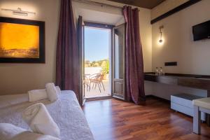 ein Wohnzimmer mit einem Bett und einer Tür zu einer Terrasse in der Unterkunft Hotel Villa De Setenil in Setenil de las Bodegas