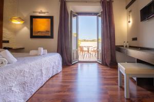 a bedroom with a bed and a view of a balcony at Hotel Villa De Setenil in Setenil