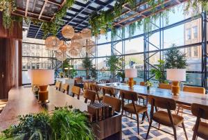 uma grande sala com mesas, cadeiras e plantas em The Green em Dublin