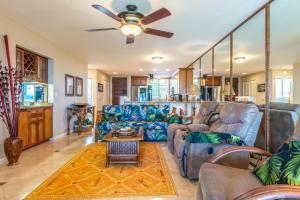 ein Wohnzimmer mit Sofas und einem Deckenventilator in der Unterkunft Country Club Villas 124 in Kailua-Kona