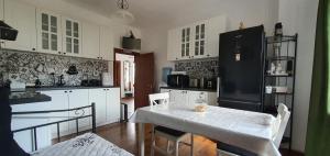 a kitchen with a white table and a black refrigerator at Guest house Eolea in Biser