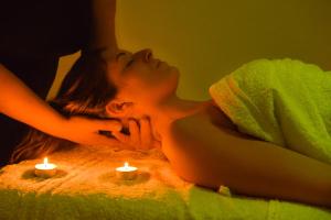 Una mujer acostada en una cama con dos velas en Agriturismo Airone en Pitigliano