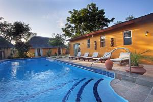 a swimming pool in front of a house at Normann Safari Bush Lodge in Phalaborwa