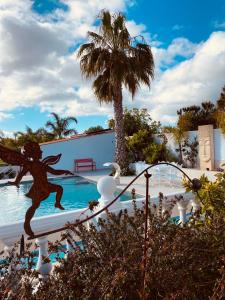 uma estátua de uma sereia junto a uma piscina em Palm View Guesthouse, adults only na Praia da Luz