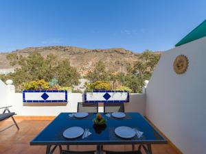a blue table on a balcony with a view at Amarre Pool in Puerto de Mogán