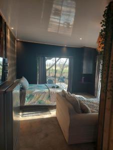 a living room with a bed and a couch at Vulture's View 8 in Hartbeespoort