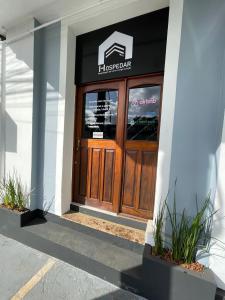 uma porta da frente de um hotel com um sinal em Hospedar Flats & Residence em Santa Cruz do Sul