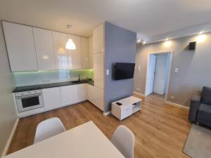 a kitchen and living room with a table and chairs at Apartament blisko morza in Gdańsk