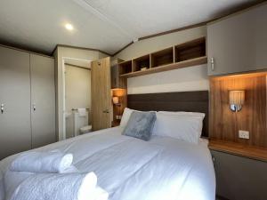 una camera da letto con un grande letto bianco con due cuscini di Stewarts Resort Lodge 54 a St Andrews