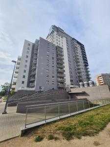 a large apartment building with stairs in front of it at Apartament blisko morza in Gdańsk