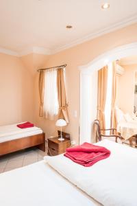 a hotel room with two beds and a chair at Kaiser Panzió in Baja