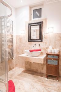 een badkamer met een wastafel en een spiegel bij Kaiser Panzió in Baja
