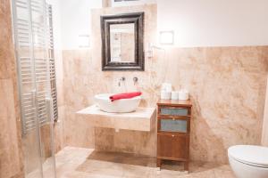 een badkamer met een wastafel, een toilet en een spiegel bij Kaiser Panzió in Baja