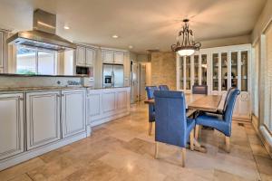 a kitchen and dining room with a table and blue chairs at Moses Lake Retreat with Salt Water Hot Tub! in Moses Lake