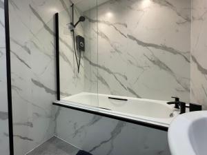 bagno con doccia, lavandino e specchio di The Haven a Greenock